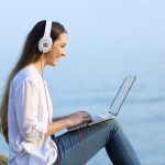 Woman watching and listening online content outdoors