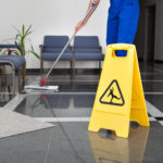 Man With Mop And Wet Floor Sign