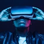 Portrait of African guy isolated on black background wearing headset of virtual reality